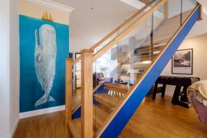 鲍内斯温德米尔Canon Craig, Luxurious Lakeland stone Cottage的墙上挂着鲸画的蓝色楼梯