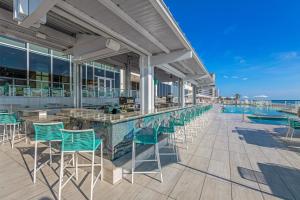 代托纳海滩Daytona Grande Oceanfront Resort的一个带绿色椅子的酒吧和一个游泳池
