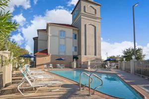 休斯顿Sonesta Essential Houston Westchase的一座带游泳池和钟楼建筑
