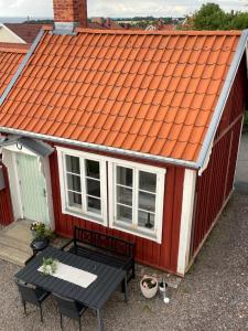 格兰纳Gårdshus - best location in the center of Gränna的红色房子的橙色屋顶,有桌子