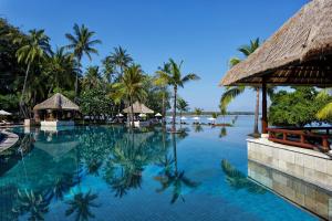 丹戎The Oberoi Beach Resort, Lombok的棕榈树度假村的游泳池