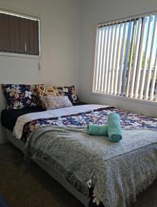 奥克兰Auckland airport holiday home的一间卧室设有两张床和大窗户