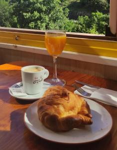 别尔萨Hostal Los Valles的一张桌子,上面放着一盘面包和一杯橙汁