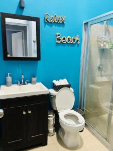 莫雷洛斯港Casa Puerto Morelos Riviera Maya的蓝色的浴室设有卫生间和淋浴。