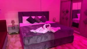 瓦迪穆萨Petra Rose Apartment的粉红色的卧室,床上配有2个粉红色的火烈鸟