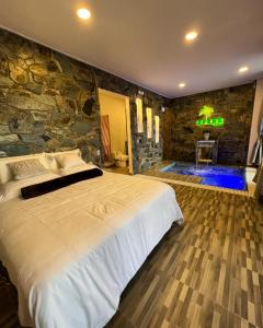 圣希尔Palmar San Gil的一间卧室设有一张大床和石墙