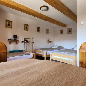 NógrádFácán-Lak的一间卧室设有三张床和横梁天花板。