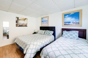 翡翠岛Hannahs Place - Quaint and Cozy Apt by the Beach!的卧室设有两张床,拥有白色的墙壁和木地板