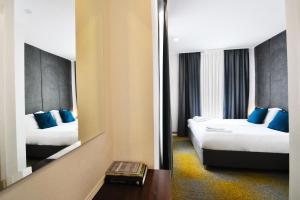 萨拉热窝Heritage Hotel Petrakija的酒店客房,设有两张床和镜子