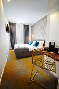 萨拉热窝Heritage Hotel Petrakija的配有一张床和一把椅子的酒店客房