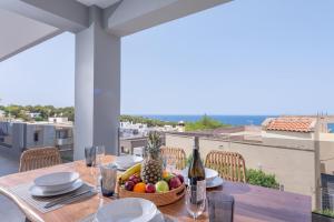 GállosLeon Luxury Home in Rethymno的一张桌子,上面放着一碗水果和一瓶葡萄酒