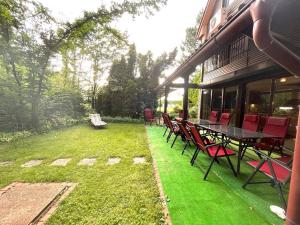 萨拉热窝Best of Ilidza and Rakovica holiday HOME的草坪上配有红色椅子和桌子的庭院