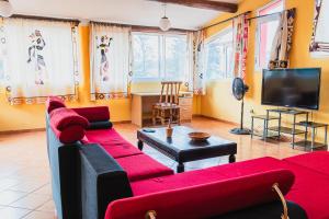 布琼布拉杰丁特瑞考酒店的客厅配有红色沙发和电视