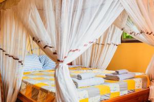 布琼布拉杰丁特瑞考酒店的一张带白色窗帘和毛巾的床
