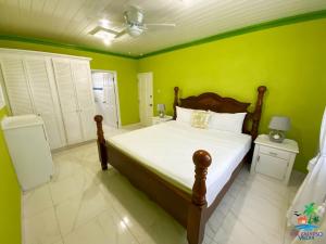 圣菲利普EHL Calypso Villa 4Bed 4.5baths, 5min to Beach的一间卧室设有一张带绿色墙壁的大床
