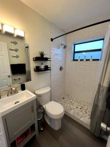 好莱坞Modern Tropical Oasis with Arcade, HotTub & MiniGolf的浴室配有卫生间、盥洗盆和淋浴。