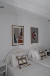 斯基亚索斯镇Fiosal Apartments 2的白色的客厅配有两张白色沙发和图片