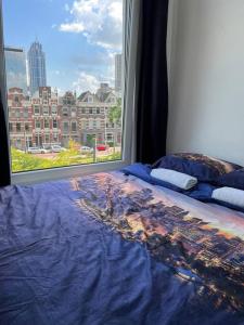 鹿特丹MyCityLofts的一张可从窗户欣赏到城市美景的床