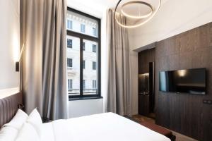 米兰Radisson Collection Hotel, Palazzo Touring Club Milan的一间卧室设有一张床和一个大窗户