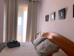 滨海罗克塔斯Rachel’s suite的一间卧室配有一张带木制床头板的床和窗户。
