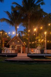 坎布塔尔Hotel Playa Cambutal的晚上有桌和棕榈树的餐厅