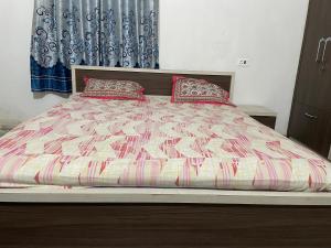 德奥加尔Parmarth Lok的卧室内的一张带两个枕头的床
