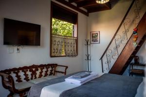 穆库热Villa Santo Antonio - Mucugê的一间卧室配有一张床、一台电视和楼梯。
