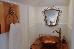 瓦尔帕莱索AYCA La Flora Hotel Boutique的一间带铜制水槽和镜子的浴室
