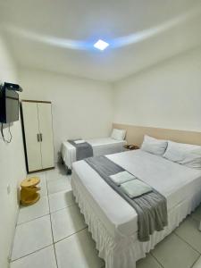 皮拉尼亚斯Pousada Girassol的一间带两张床的卧室和一台电视