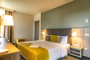 米什科尔茨道波曹Lignum Hotel的酒店客房,配有一张带黄色床单的大床