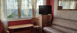 奥尔什丁Apartament z baldachimem i pięknym widokiem Olsztyna的客房设有电视、椅子和窗户。