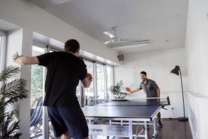 凯恩斯The Village Cairns的两个人在带乒乓球桌的房间里打乒乓球