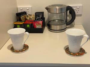 凯里凯里Te Whare Ma的两杯咖啡锅坐在柜台上