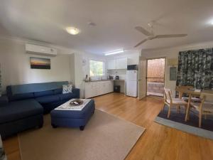 South Mission BeachMission Dreaming - 1 Bedroom Cottage的一间带蓝色沙发的客厅和一间厨房