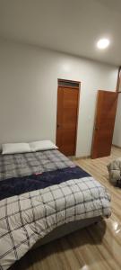 奥克萨潘帕Estancia Familiar的一间卧室配有一张床,铺有木地板