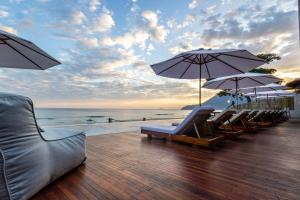 马利西亚斯Duke Beach Hotel Maresias的海滩上带椅子和遮阳伞的甲板