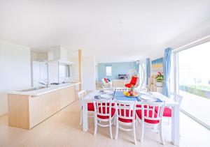 宫古岛ヴィラアマルフィ パームスプリングス宮古島リゾート的厨房以及带桌椅的用餐室。