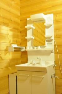 富良野Log Cottage be with nature的浴室设有白色水槽和镜子