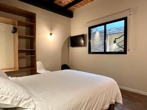 墨西哥城Casa Raffaello的卧室配有白色的床和窗户。