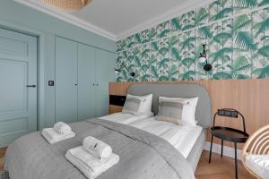 索波特Lion Apartments - Havana Premium Family Stay的一间卧室配有一张大床和毛巾