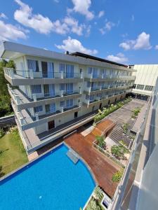 TanjungbingaDafam Resort Belitung的公寓大楼旁设有游泳池