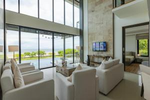 华欣BeachFront Modern 4 Bedroom Pool Villa RV的客厅配有白色家具和大窗户