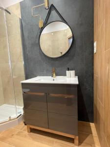 克拉科夫Aparthotel Cracow的一间带水槽和镜子的浴室