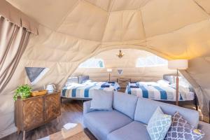 岛田Glamping&Port結的带沙发的客厅和带两张床的帐篷