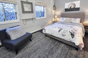 芬加尔湾Fingal Pines Getaway, Apartment的一间卧室配有一张床、一把椅子和窗户。
