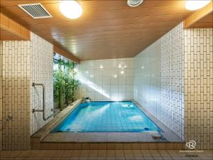名古屋Daiwa Roynet Hotel Nagoya Fushimi的一个带游泳池的瓷砖墙浴室