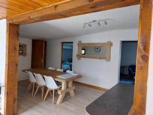 莱德萨阿尔卑斯La Maison de Charlie Les 2 Alpes的一间带木桌和椅子的用餐室