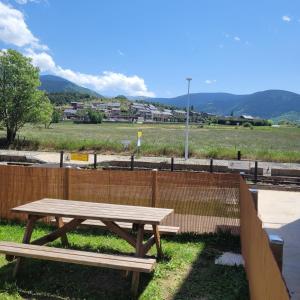赛拉古斯Loft mansardé du train jaune avec vue sur les montagnes的围栏旁的木餐桌