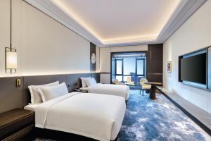 保定雄安朗悦voco酒店的酒店客房设有两张床和一台平面电视。