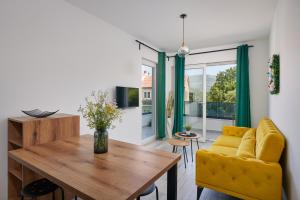 西利皮Apartments Endji的客厅设有黄色的沙发和木桌